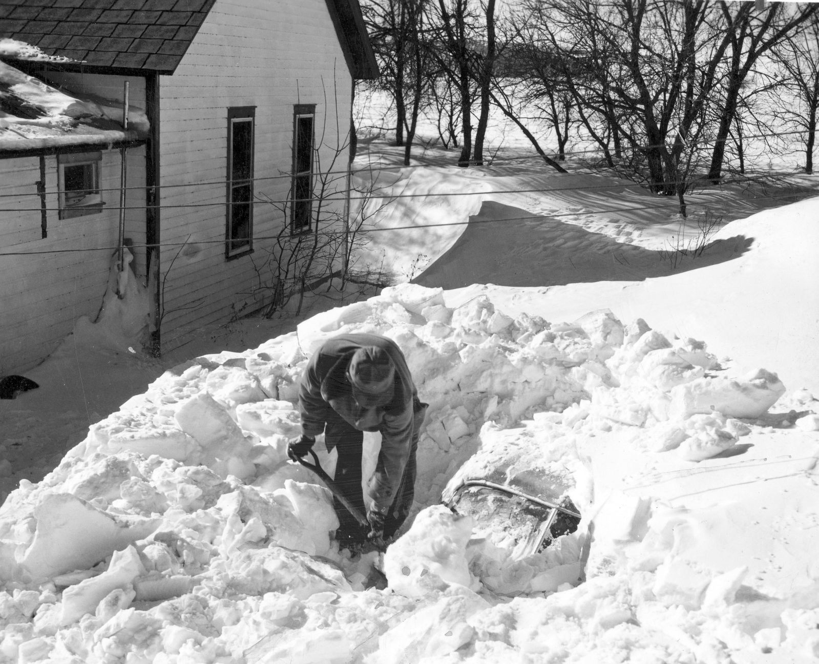 Digging out the family car at the Price ranch west of Horn. Drifts were almost 18 feet. Published Feb. 12, 1949.
